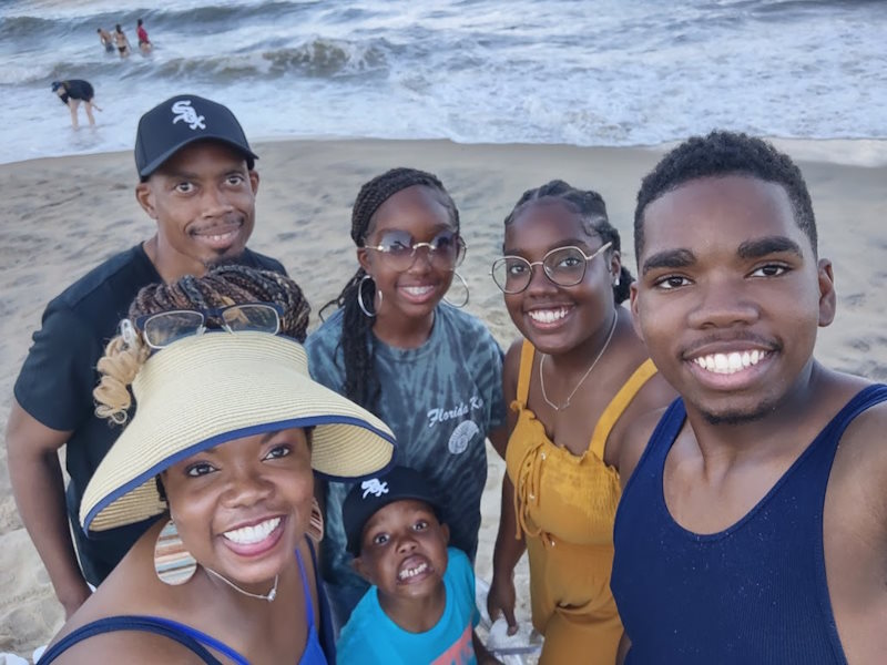 A smiling family of six at the beach.
