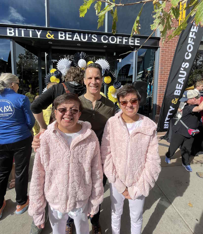 Jason smiles outside of Bitty & Beau’s shop with his two daughters.