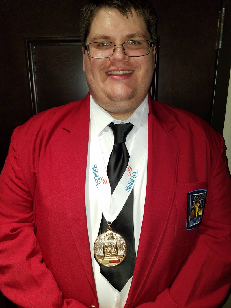 Andy wears a red blazer with an embroidered emblem and SkillsUSA medal around his neck.