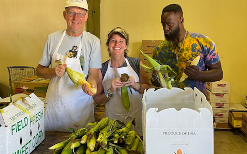 Beth smiles while preparing food with fellow volunteers.