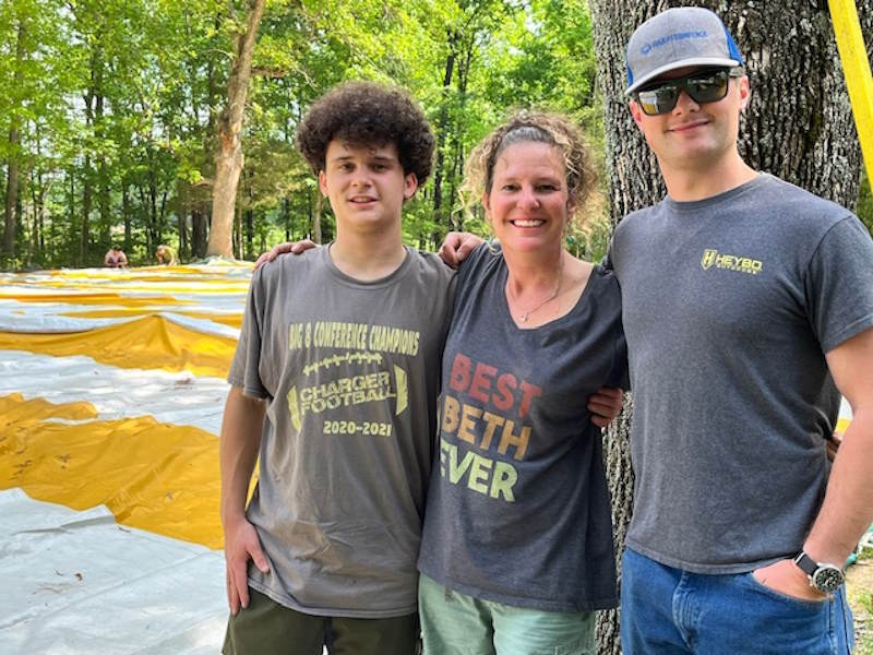 Beth and her two sons  near a large festival tent being erected.