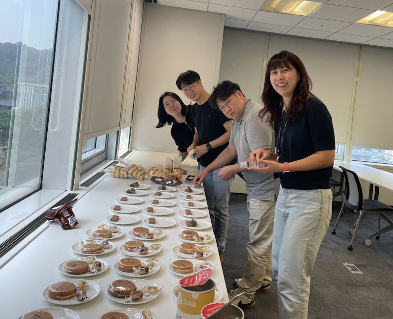 A group of Cisco volunteers next to a table filled with cultural foods.