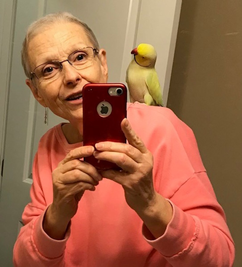 Catherine takes a selfie with a bird on her shoulder.