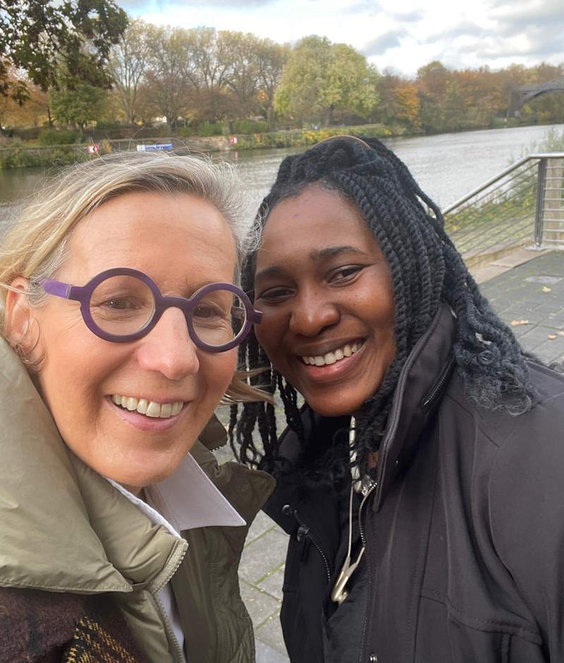 Two women take a selfie together at a park.