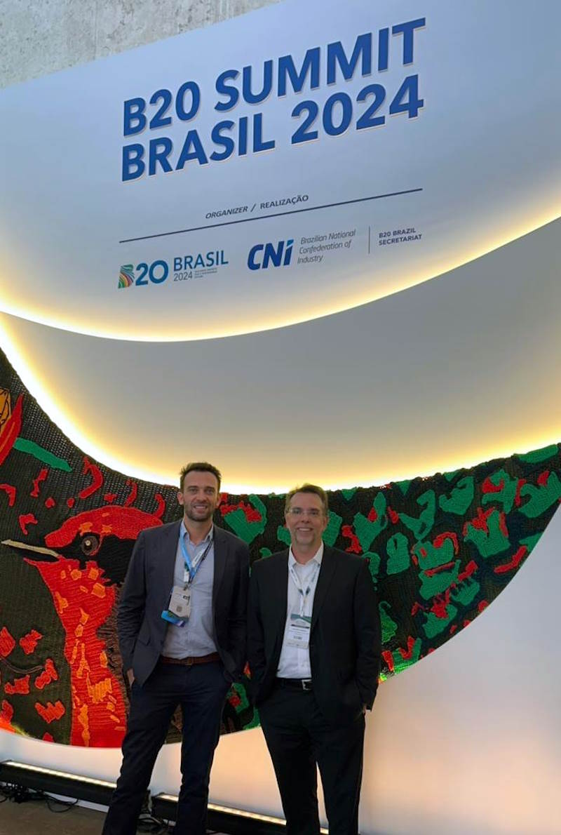 Gabriel and Giuseppe stand near a B20 Summit Brasil 2024 sign.