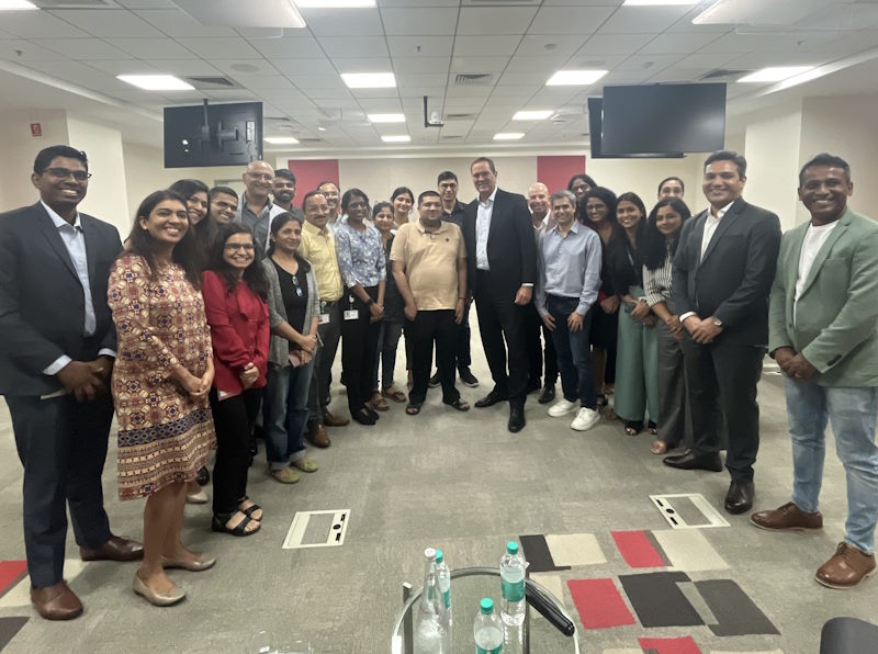 Employees pose for a group photo in a room at the Bangalore campus.