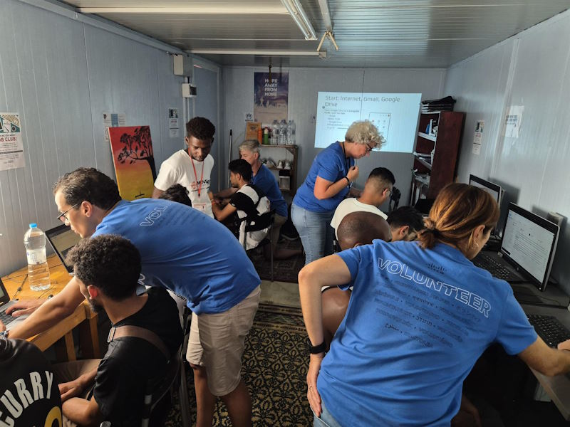 Cisco volunteers in the classroom demonstrate computer skills to some of the camp refugees. 