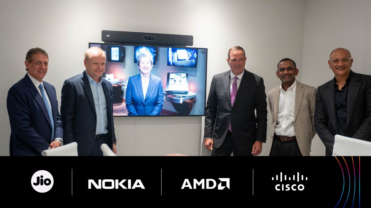 Photographed from L to R: Phil Guido, EVP & CCO, AMD; Pekka Lundmark, President & CEO, Nokia; (on screen) Dr. Lisa Su, CEO, AMD; Chuck Robbins, Chair & CEO, Cisco; Mathew Oommen, Group CEO, Reliance Jio; and Jeetu Patel, EVP & CPO, Cisco.