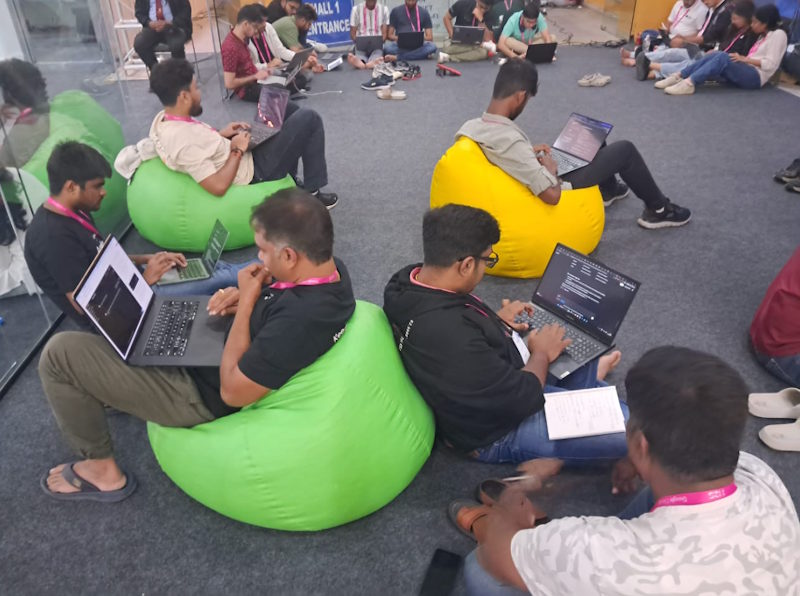 People sit on bean bags, focused on their laptops and deep in thought.