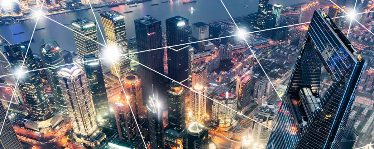 Illustration: Aerial city at night with a glowing network overlay symbolizing AI and intelligent networking.